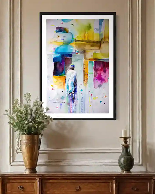 Framed colorful abstract art print by artist Galal Yousif on a wall with decorative vases on side table below. in UAE