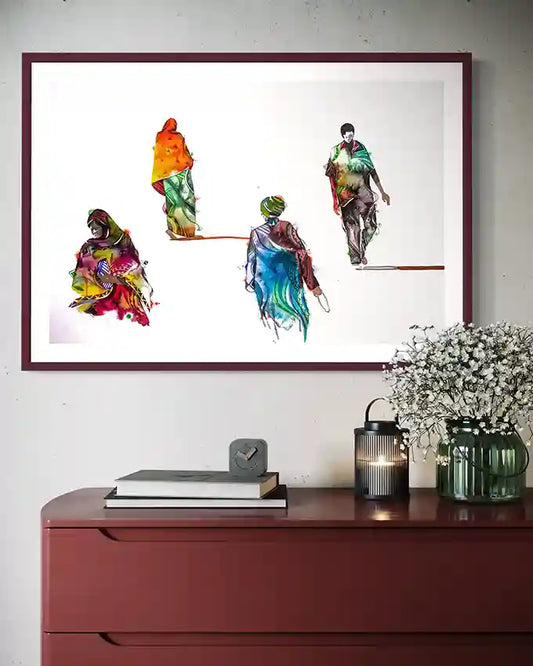 Framed abstract art print of people on a white wall above a red cabinet. by visual Sudanese artis Galal Yousif, in UAE