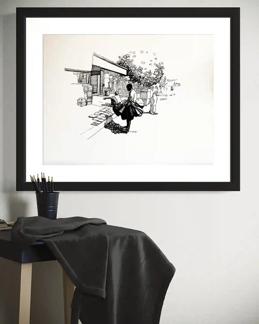 A Moment in Time framed ink painting by Obada Gabir above desk showing street vendor browsing books mockup