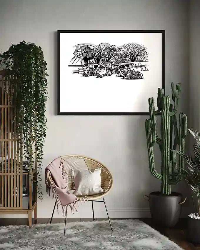 Desert Caravan at Rest art print by Obada Gabir in black frame displayed in modern boho living room with plants and chair