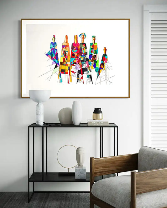 'Community Influences' art print by artist Yousif Ibrahim on a wall above a black console table with decorative items. UAE