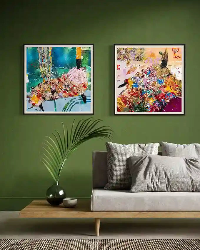  Two Hani Khalil abstract art prints in black frames on green wall above gray sofa with palm plant and wooden side table