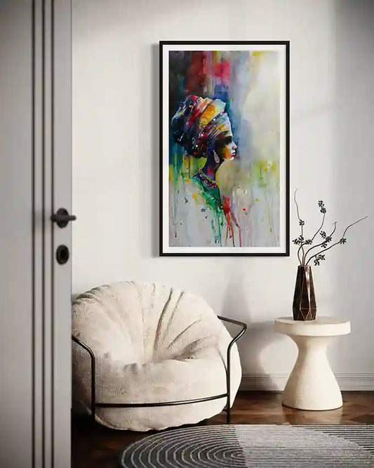 Colorful framed art print by Galal Yousif with a face of an African woman on a wall above a white armchair.in UAE