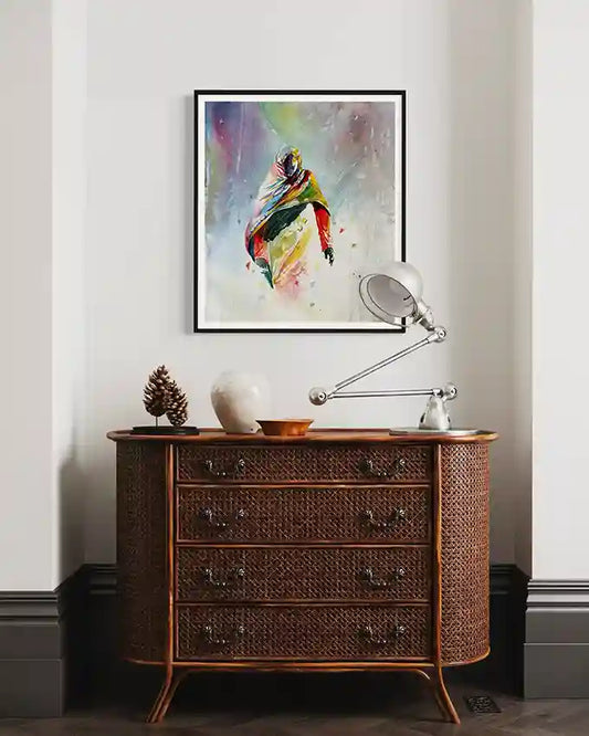 Wooden dresser with decorative items and a colorful abstract Sudanese woman on a white wall, art print by visual Sudanese artist Galal Yousif, in UAE