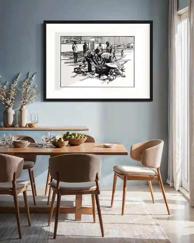 Framed Community Kitchen art print by Obada Gabir hanging above modern dining table with wooden chairs and tableware