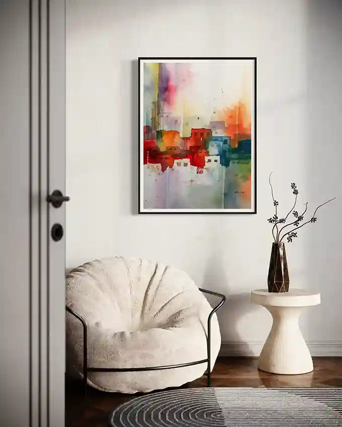 Framed art print by Sudanese visual artist Galal Yousif in Modern interior with white armchair, and small table with a vase.