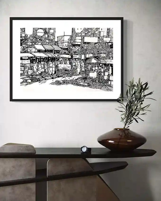 Framed "Between the Lines" art print by Osman Gouma displayed on modern console table with decorative vase and olive branch