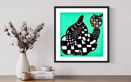 Blue Orange artwork by Usra Hamza in black frame on wall with dried flowers and Kinfolk books creating minimalist display