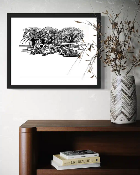 Camel Caravan framed ink painting by Obada Gabir displayed on wall above wooden console with vase and books home decor