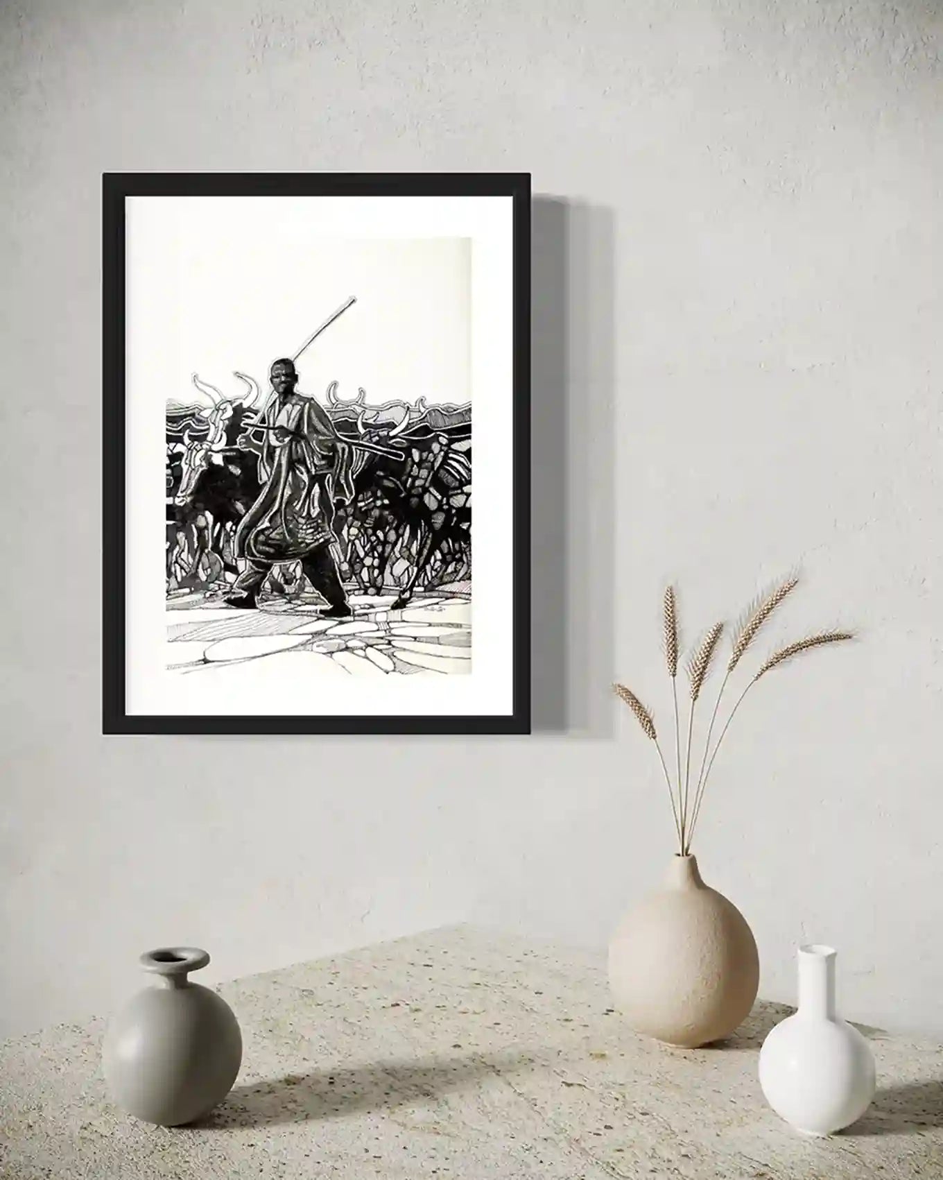 The Cattle Herder framed art print by Obada Gabir displayed in modern interior with ceramic vases and dried grass