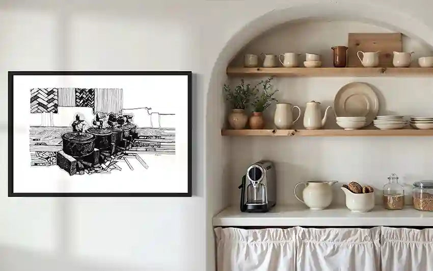 Cooking Pots black and white art print by Obada Gabir displayed in rustic kitchen pantry with ceramic dishes and natural shelving