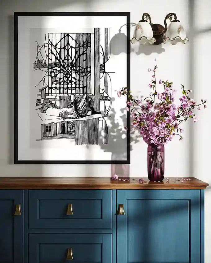 Feed Your Mind art print by Obada Gabir displayed in black frame above blue cabinet with purple flowers and vintage lighting