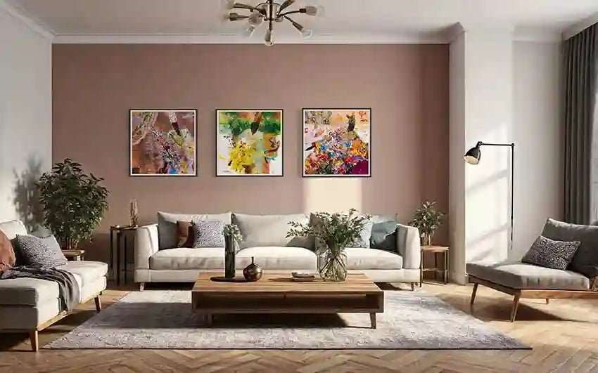 Three Hani Khalil Sufi prints as gallery wall above modern sofa on terracotta wall, showing contemporary Sudanese art 