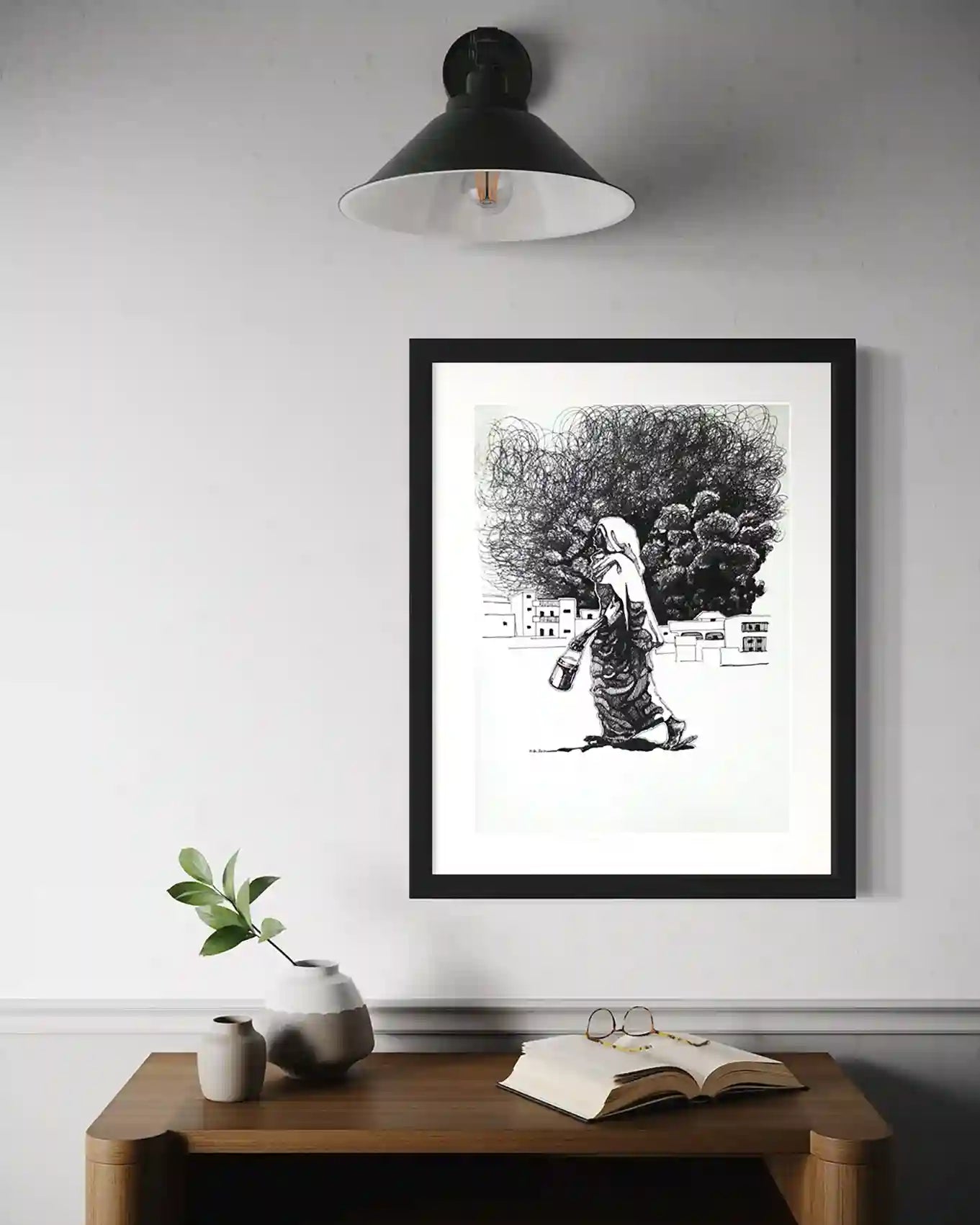 Rhythm of her Step by Obada Gabir framed ink painting mockup on wall above wooden desk with plant and books