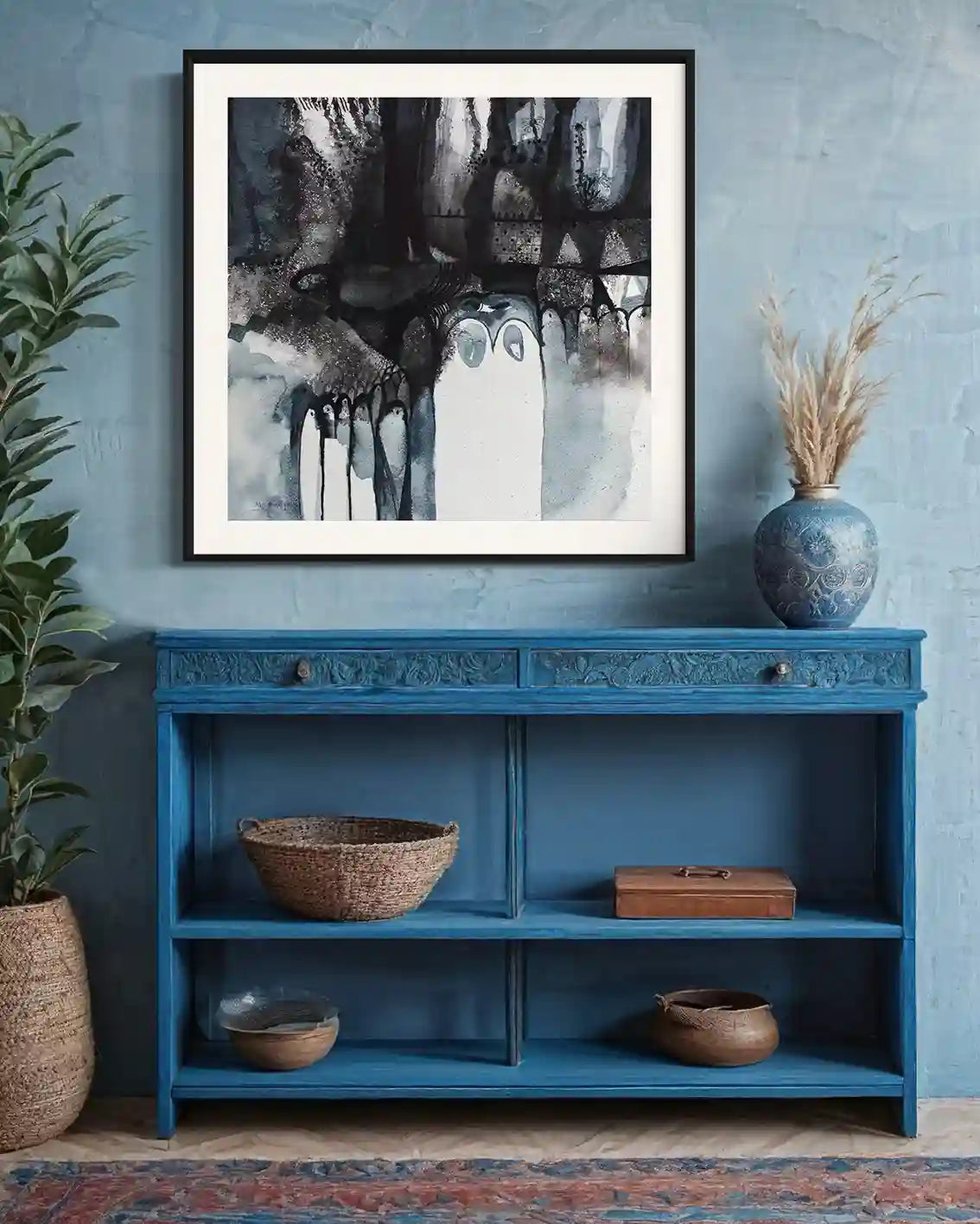 Shadow Play art print by Abushariaa Ahmed displayed in black frame on blue console table in modern interior setting