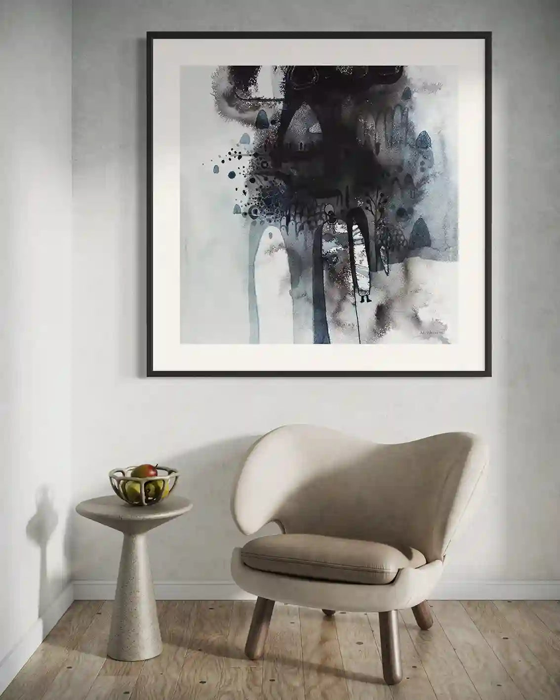 "Through the Mist" art print by Abushariaa Ahmed framed above beige chair and side table in modern room